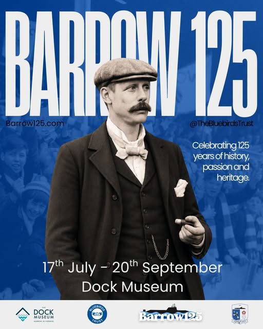 A poster for Barrow 125 with a blue background. An old black and white phot shows a man with flat cap, large moustache, jacket and waistcoat with watch chain visible. He's wearing a white shirt with small scarf tied at the neck.